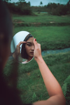 a woman looking at her reflection in a mirror 