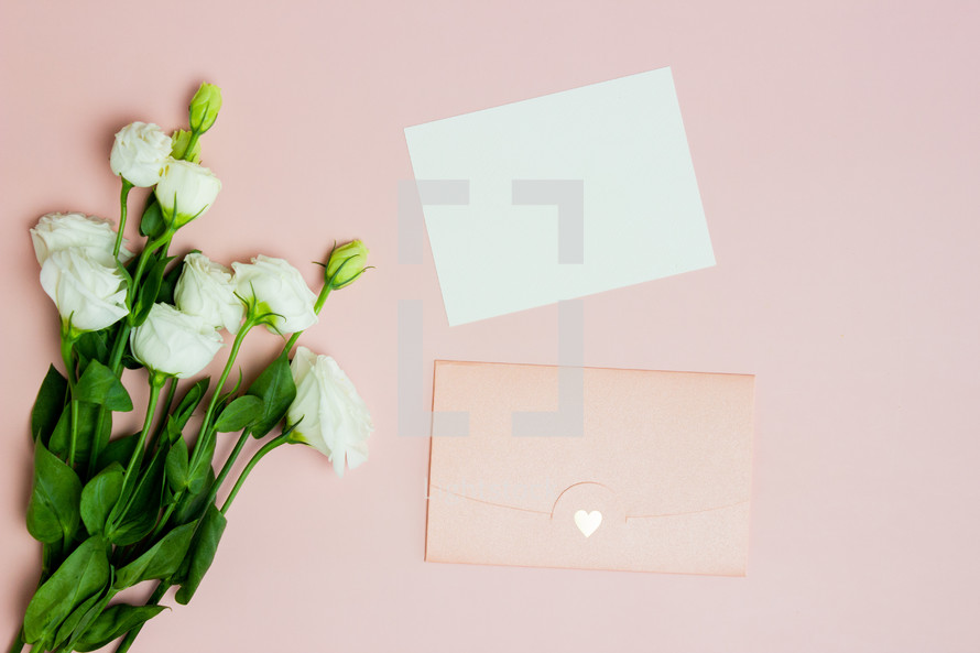 white roses and pink envelope 