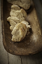 Broken pieces of bread on a wooden tray