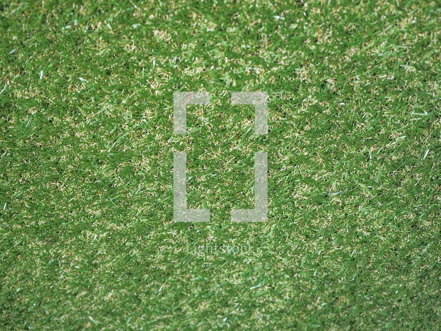 Green artificial synthetic grass meadow texture useful as a background