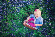 Happy little girl in field of purple wildflowers
