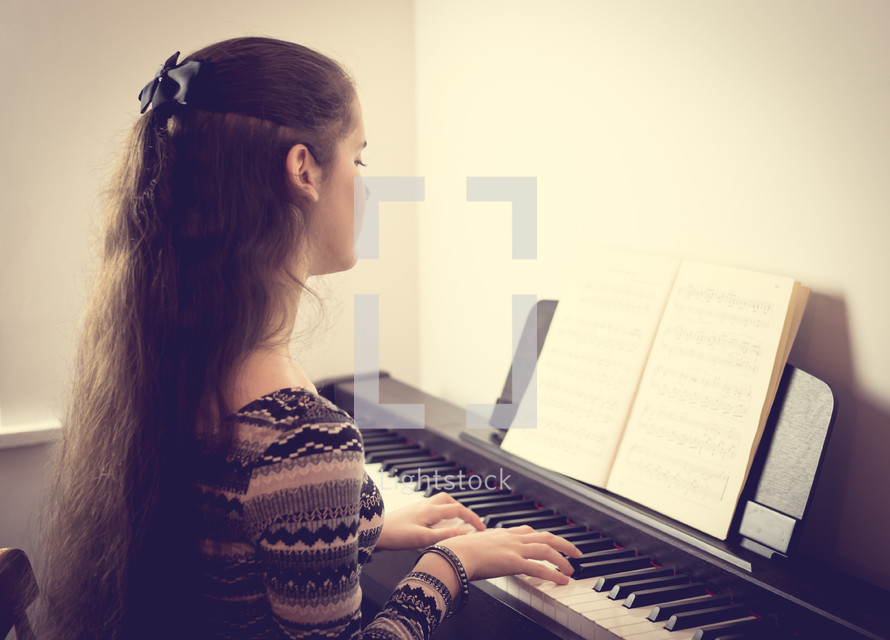 teenage girl playing a piano 