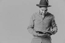 man in a hat reading a Bible 