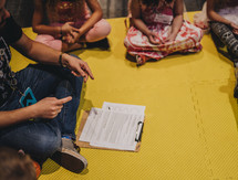 children learning sitting on a floor in a circle 