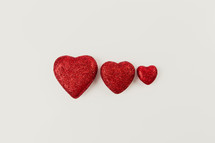 three red hearts on a white background 