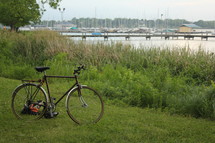 bike parked in the grass by a marina 