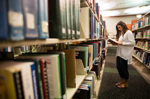 woman looking at books in a library 