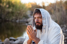 Jesus with his hands held in prayer