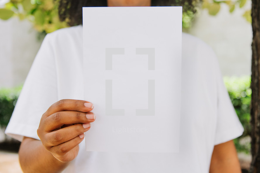 Close up of a woman holding up a blank flyer.