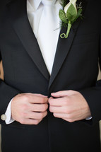 torso of a groom and his boutonniere