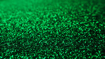 Abstract emerald background with shining sparkles. Glittering Particles surface. Festive dust. Beautiful texture, bokeh. New Year party concept.