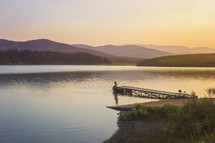 dock at a lake at sunset 