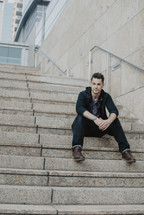 a man sitting on concrete steps 