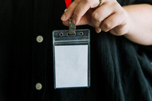 Woman in a black shirt wearing a lanyard.