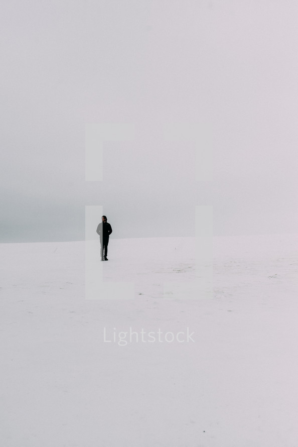 man standing alone in snow 