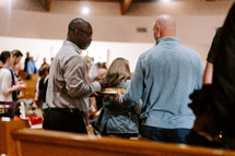 passing around offering trays during a worship service 