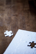 White jigsaw puzzle with piece missing.