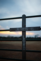 Jesus is Lord - words on a cross on a fence 