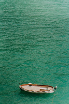 aerial view over a boat on turquoise water 