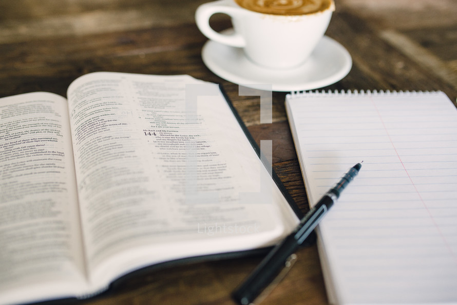 cappuccino and an open Bible and notepad and pen 