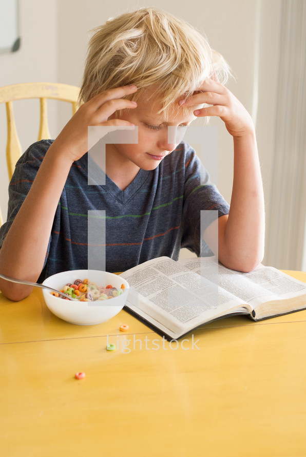 morning devotional, boy child reading his Bible and eating milk and cereal 