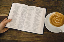 man reading a Bible and cappuccino 