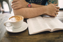 cappuccino and a man reading a Bible in a coffee shop 