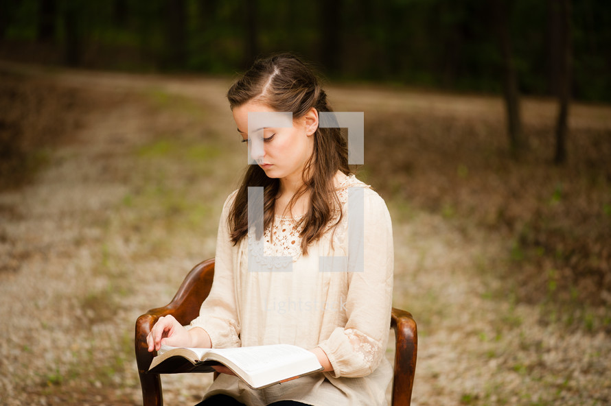 young woman sitting and reading a Bible 