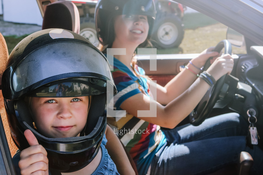 a young teen learning to drive wearing helmets