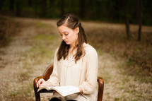 young woman sitting and reading a Bible 