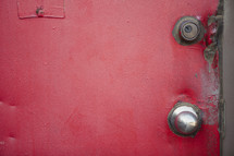 dents in a red metal door