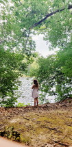 girl standing on a lake shore in summer 