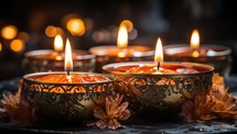 Burning candles in bowls with flowers on dark background, closeup