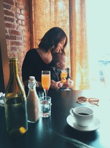 mother holding her infant and mimosas 