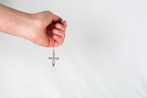hand holding a cross necklace 