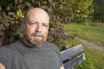 a man sitting on a wooden bench outdoors 