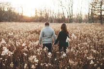 a couple standing in a field 
