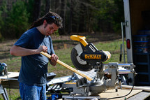 a man using a saw to cut lumber 