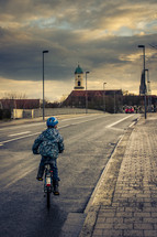 a child in a helmet riding his bike 