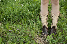 child in cowboy boots in grass