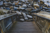 steps leading to rocks at a shore 