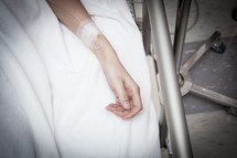 arm with an iv in a hospital bed 