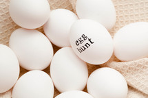 word Egg hunt on white chicken eggs 