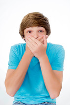 teen boy covering his mouth