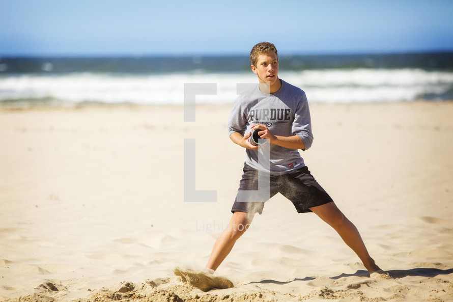 teen boy playing on a beach 