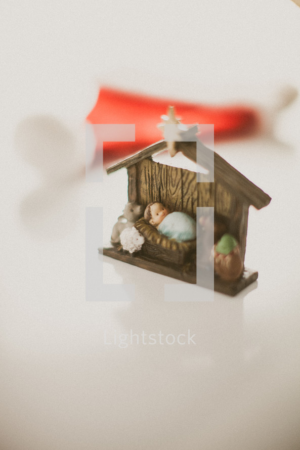 The Manger scene in front of a red Santa hat