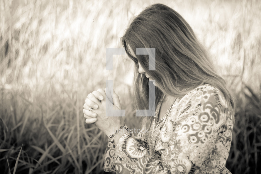 woman praying in a field 