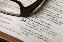 Reading glasses on top of Bible open to Psalm 34.
