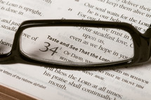 Reading glasses on top of Bible open to Psalm 34.