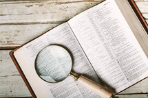 Magnifying glass on pages Bible open to Psalm 119.